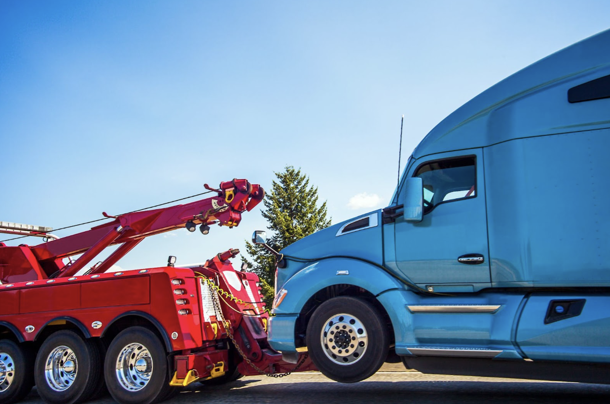 a tow truck towing a semi truck